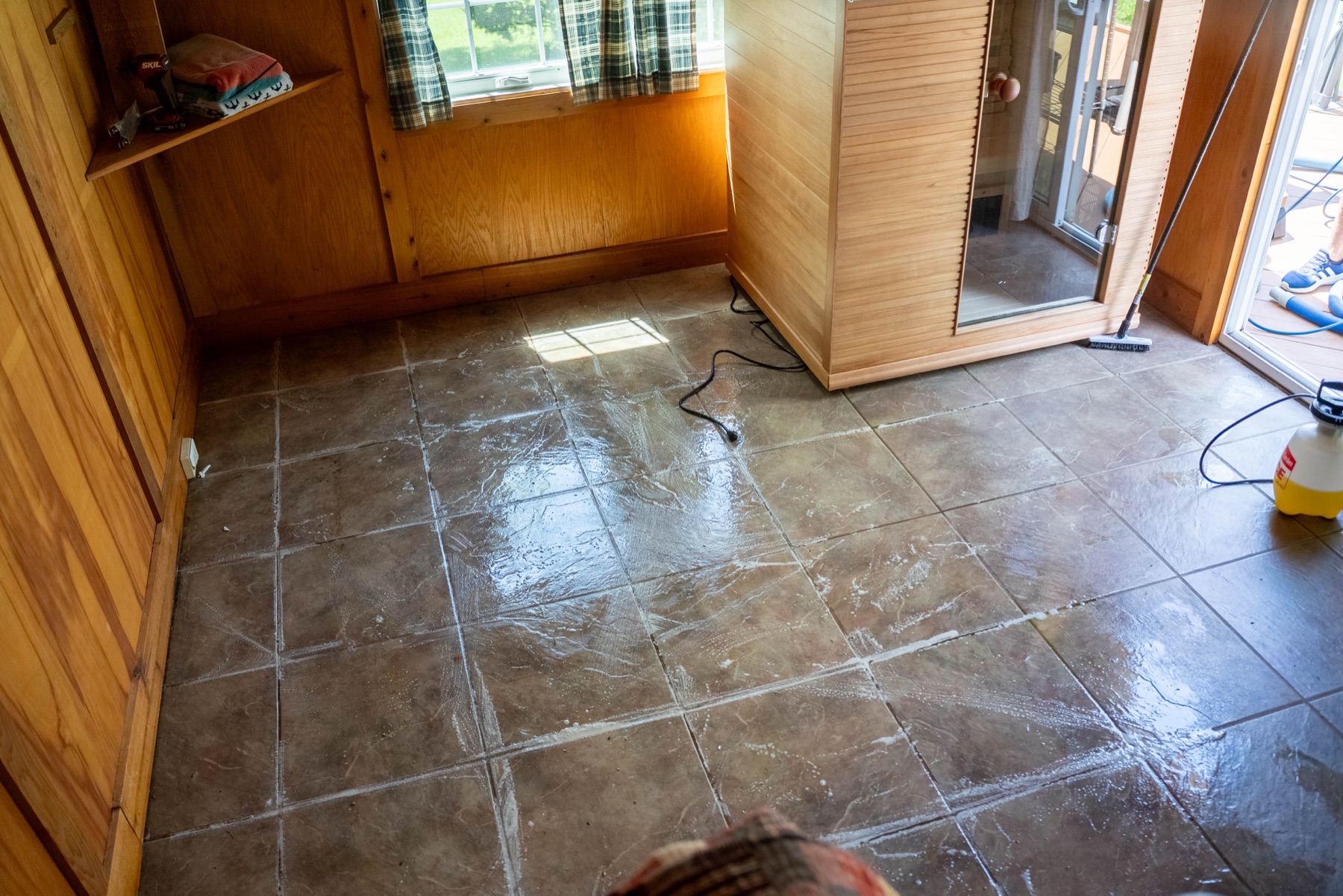 PowerSteam technician scrubbing a tile floor
